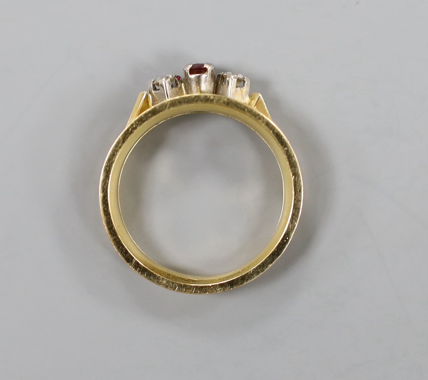 A modern 18ct, ruby and diamond set three stone ring, size Q, gross weight 5.7 grams.